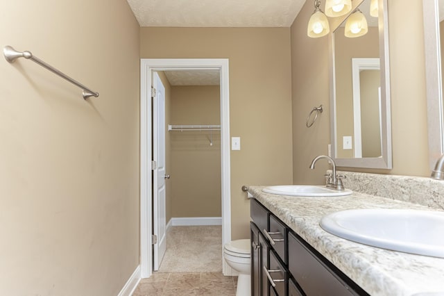 bathroom featuring vanity, a textured ceiling, and toilet