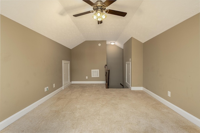 bonus room featuring vaulted ceiling, light carpet, a textured ceiling, and ceiling fan