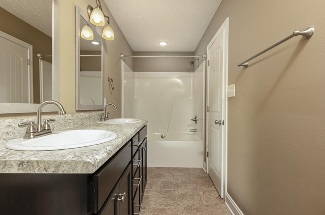 bathroom with vanity, shower / bath combination, and a textured ceiling