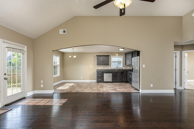 unfurnished living room with ceiling fan with notable chandelier, wood-type flooring, and vaulted ceiling