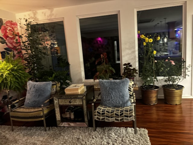 living area featuring visible vents and wood finished floors