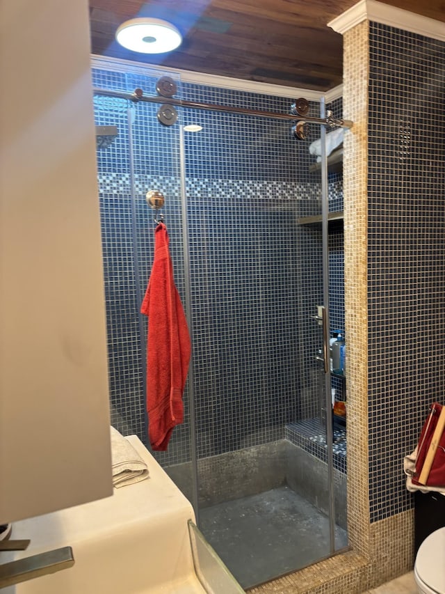 bathroom featuring a shower stall, toilet, wood ceiling, and ornamental molding