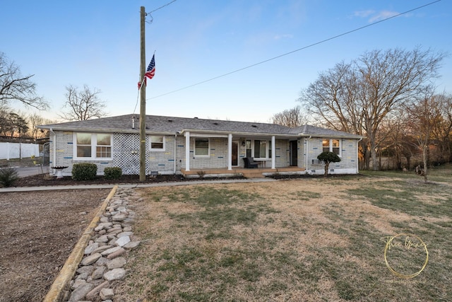 ranch-style house featuring a porch, a front yard, and fence