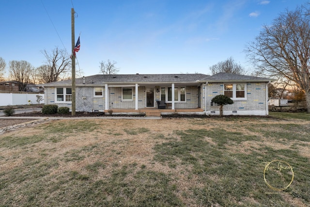 ranch-style home with brick siding, a front yard, fence, and covered porch