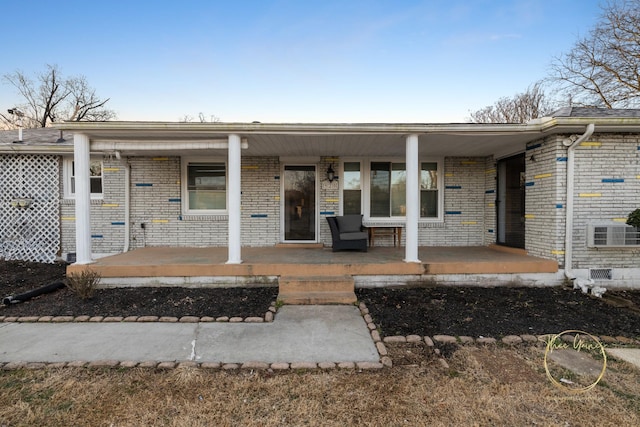 exterior space featuring brick siding and covered porch