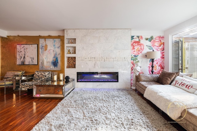 living room with wood finished floors and a tile fireplace