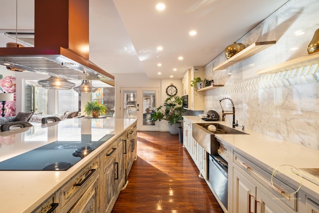 kitchen featuring a sink, island exhaust hood, dark wood-style floors, light countertops, and decorative backsplash