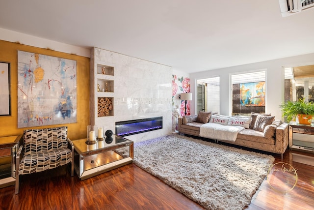 living room with a tiled fireplace, visible vents, and wood finished floors