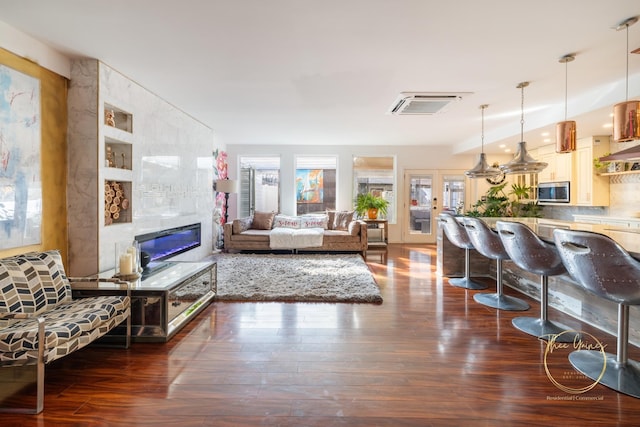 living area with a fireplace, wood finished floors, and visible vents