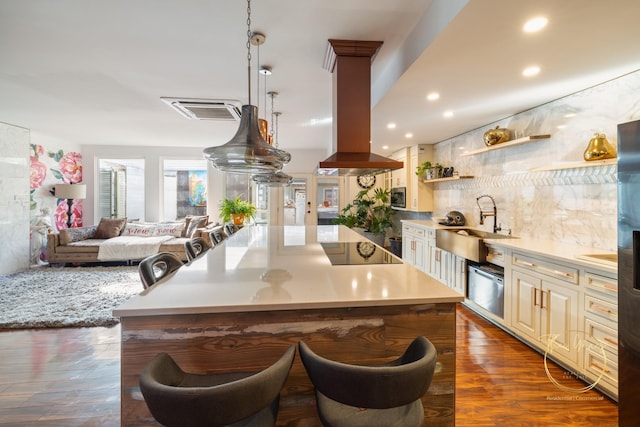 kitchen with open shelves, black electric stovetop, light countertops, island exhaust hood, and a sink