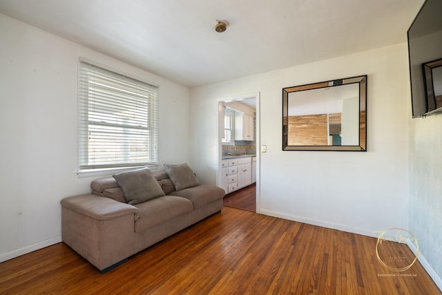 living area featuring baseboards and hardwood / wood-style flooring