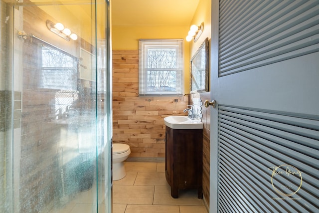 bathroom with wooden walls, a shower stall, toilet, tile patterned floors, and vanity