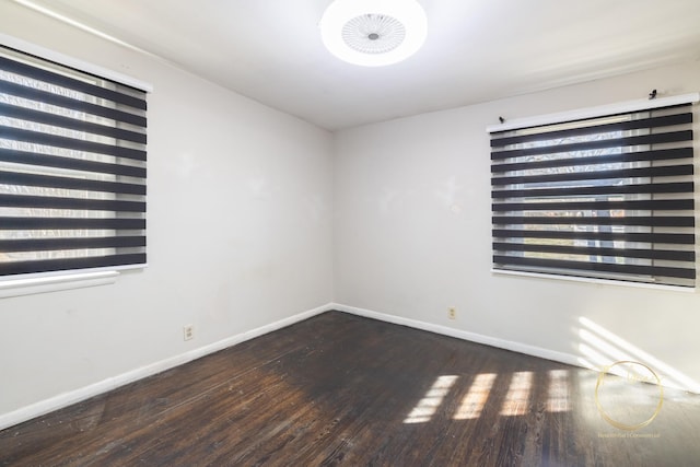 unfurnished room with baseboards, a healthy amount of sunlight, and wood finished floors