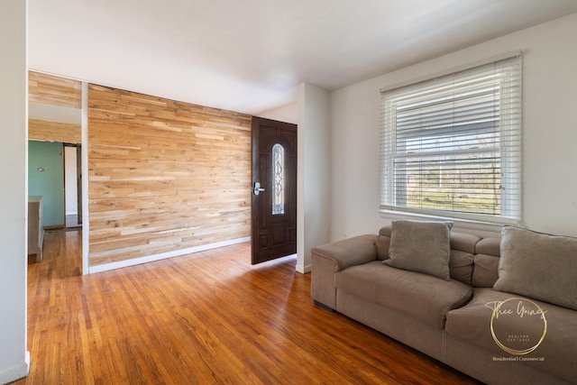 living area with wood finished floors and wood walls