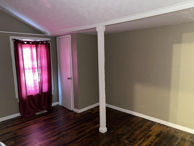 empty room featuring dark hardwood / wood-style flooring and vaulted ceiling