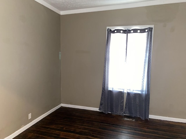 empty room featuring crown molding, dark wood-type flooring, and a textured ceiling