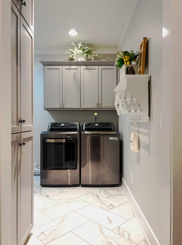 washroom with cabinets and washing machine and clothes dryer