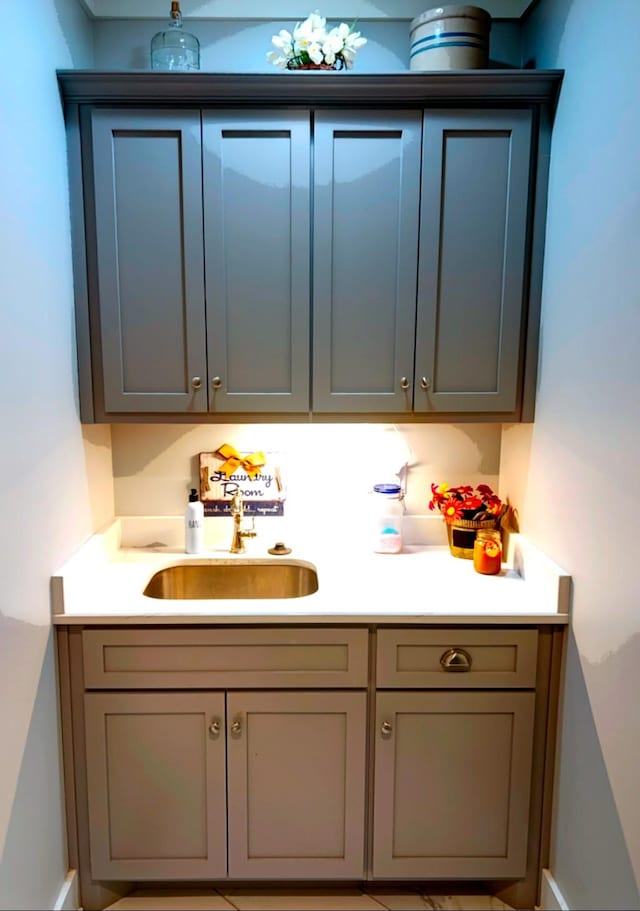 bar with sink and gray cabinetry