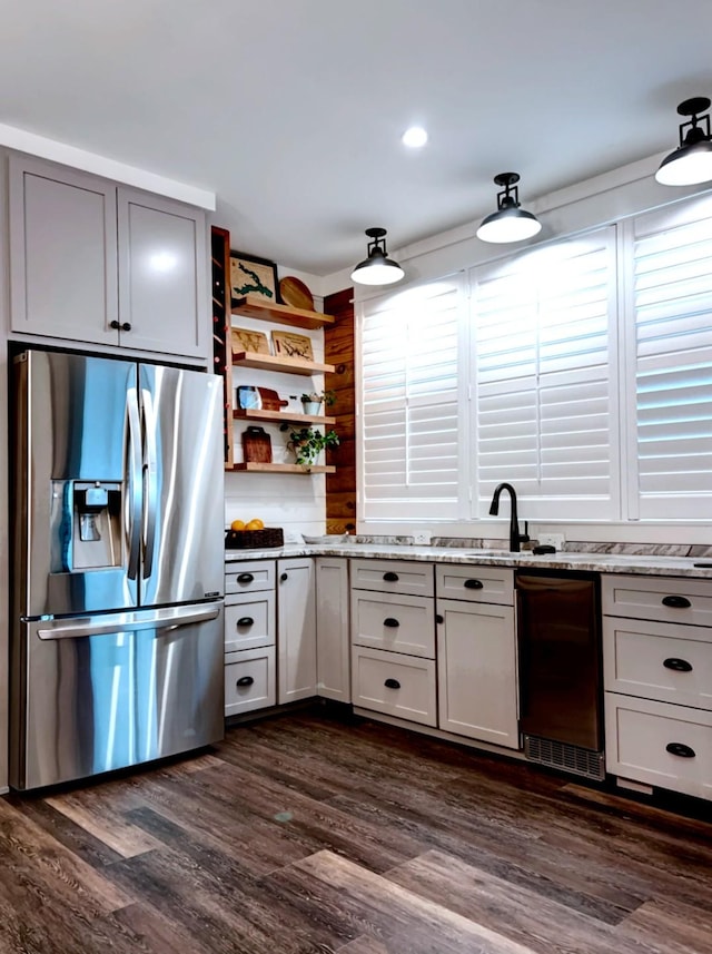 kitchen featuring white cabinetry, light stone countertops, dark hardwood / wood-style floors, and stainless steel fridge