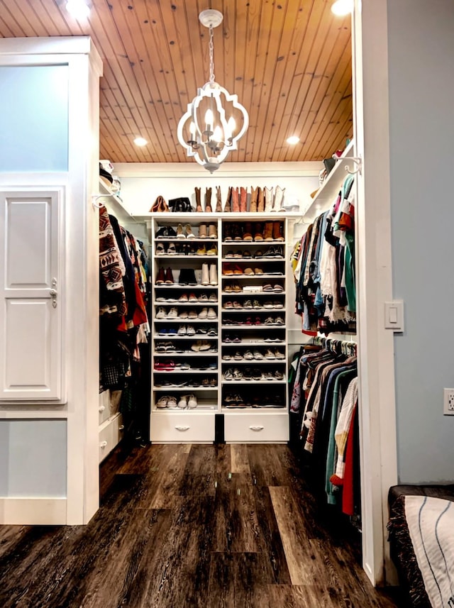 walk in closet featuring dark hardwood / wood-style flooring and a chandelier