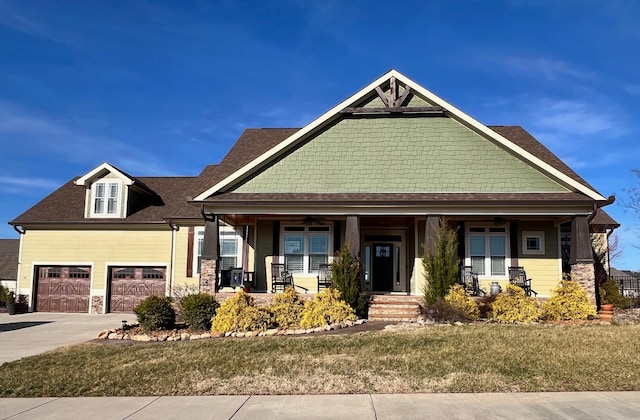 craftsman inspired home with a garage, a front yard, and covered porch