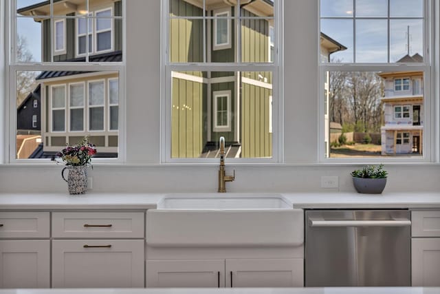 kitchen with white cabinetry, dishwasher, and sink