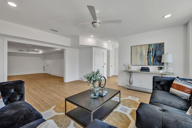 living room featuring ceiling fan and light hardwood / wood-style flooring