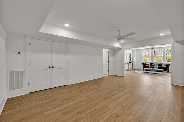 unfurnished living room featuring ceiling fan and light wood-type flooring