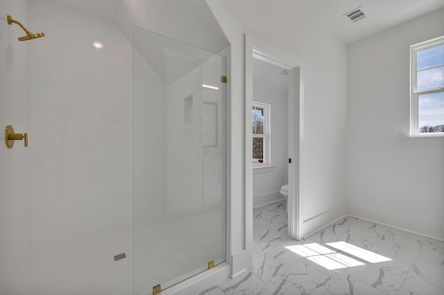 bathroom featuring plenty of natural light, tiled shower, and toilet