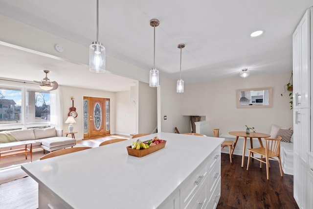 kitchen featuring white cabinetry, pendant lighting, dark wood-type flooring, and a center island