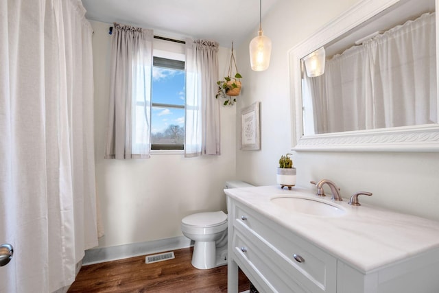 bathroom with vanity, toilet, and hardwood / wood-style floors