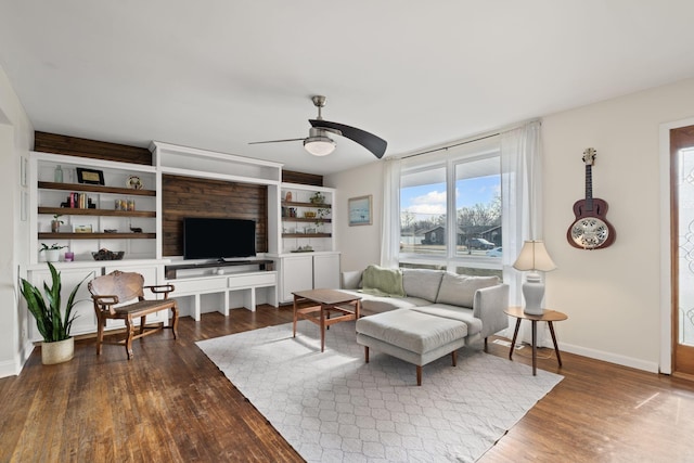 living room featuring ceiling fan and dark hardwood / wood-style flooring