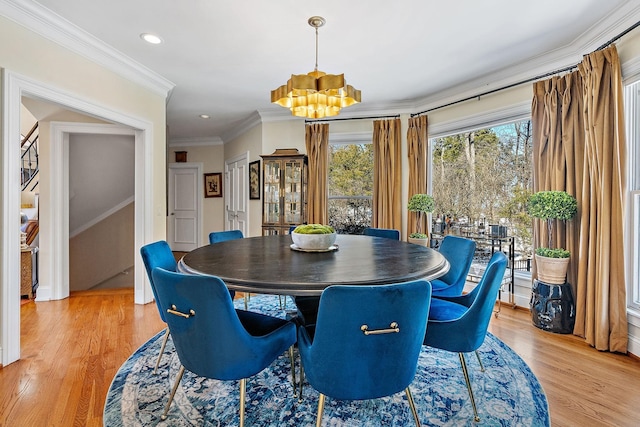 dining room featuring crown molding, a notable chandelier, and light hardwood / wood-style flooring