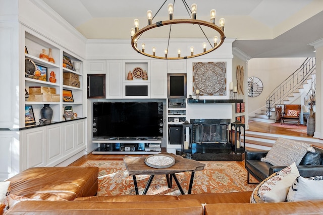 living room featuring crown molding, a tray ceiling, an inviting chandelier, and light hardwood / wood-style floors