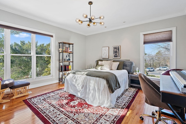 bedroom with an inviting chandelier, crown molding, hardwood / wood-style floors, and multiple windows