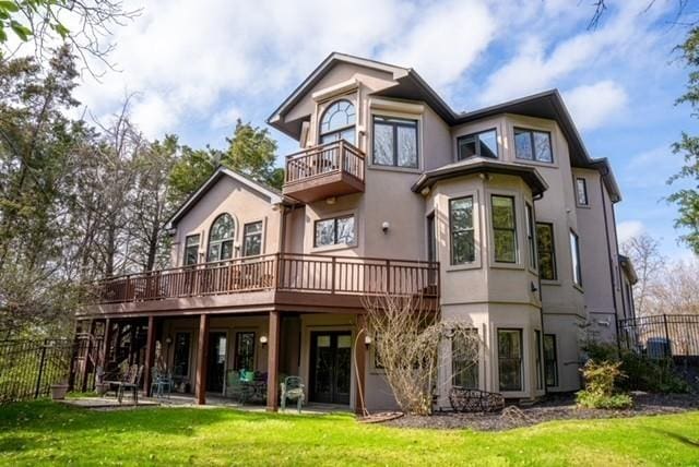 rear view of property featuring a yard and a deck