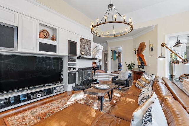 living room featuring wood-type flooring, an inviting chandelier, crown molding, and built in shelves