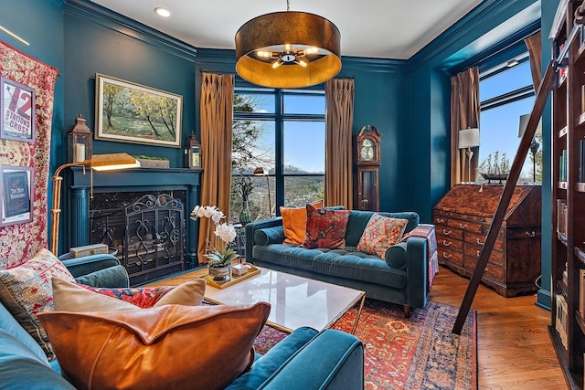 living room with hardwood / wood-style flooring, crown molding, a wealth of natural light, and a high end fireplace