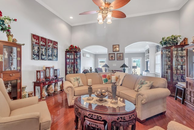 living room with hardwood / wood-style floors, crown molding, and ceiling fan