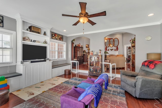 living room with crown molding, dark hardwood / wood-style floors, and ceiling fan