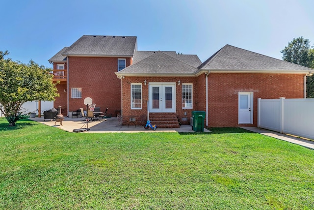 rear view of house featuring french doors, a yard, and a patio area