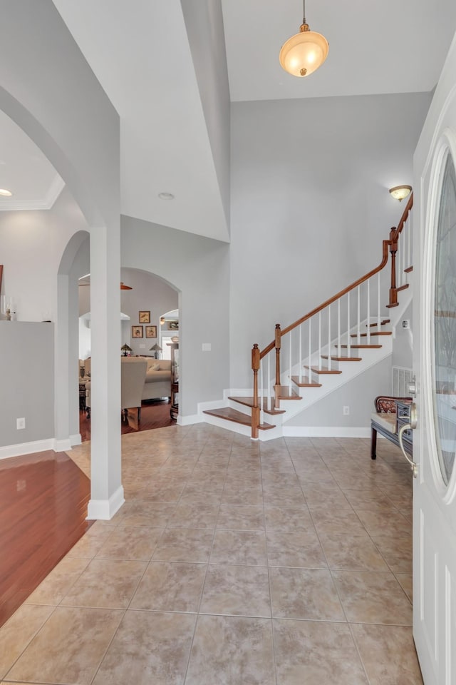 entryway with crown molding and light tile patterned flooring