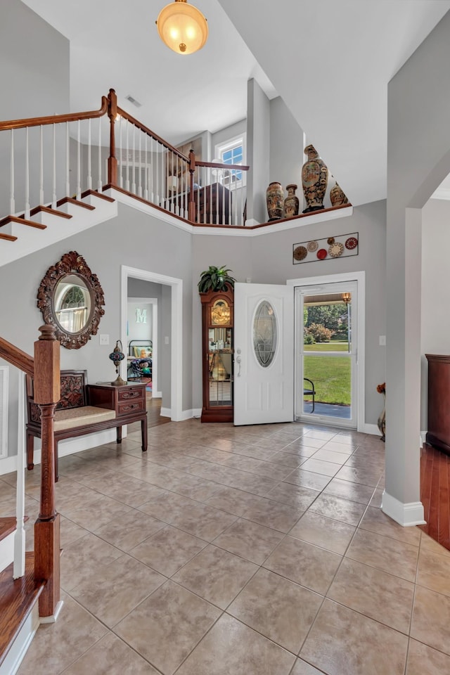 foyer with a towering ceiling and light tile patterned floors