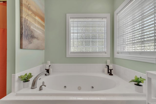 bathroom with plenty of natural light and tiled bath