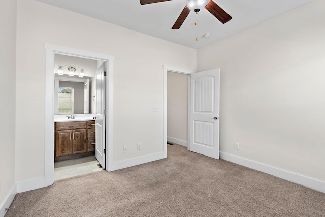 unfurnished bedroom with sink, connected bathroom, light colored carpet, and ceiling fan