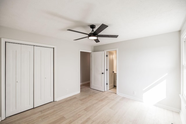 unfurnished bedroom with ensuite bath, ceiling fan, light hardwood / wood-style floors, a textured ceiling, and a closet