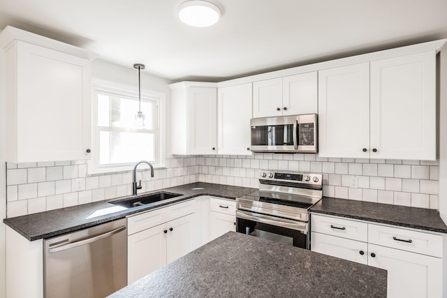 kitchen with sink, appliances with stainless steel finishes, hanging light fixtures, tasteful backsplash, and white cabinets