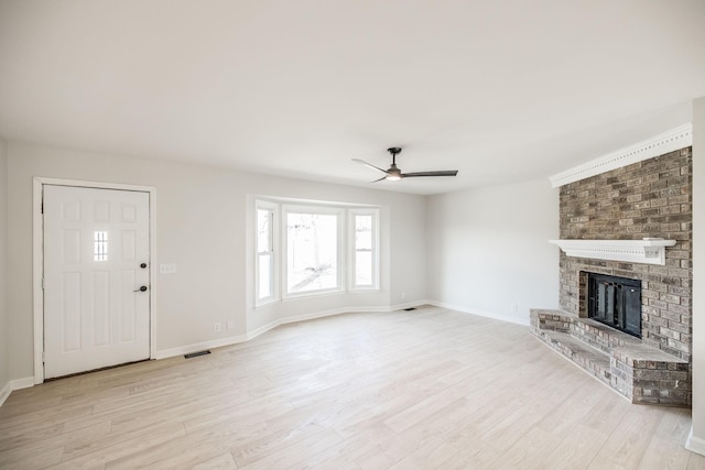 unfurnished living room with ceiling fan, a fireplace, and light hardwood / wood-style floors