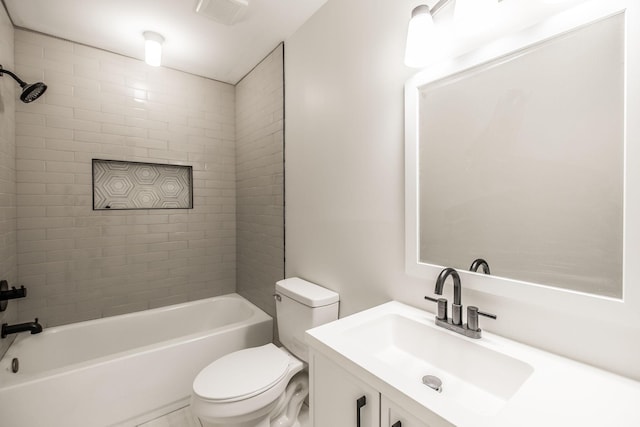 full bathroom featuring vanity, tiled shower / bath combo, and toilet