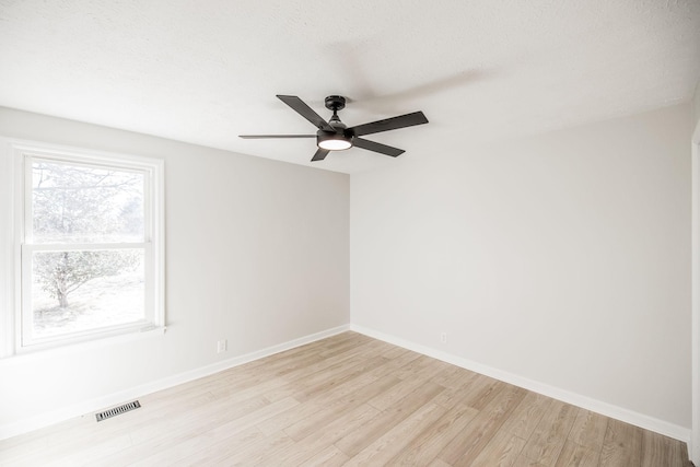 spare room with a textured ceiling, light hardwood / wood-style floors, and ceiling fan